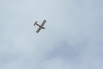 A counter-rotated shot of the bottom of a propeller plane flying through the sky