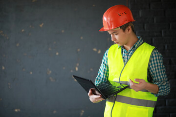 Asian man in protective helmet and construction waistcoat