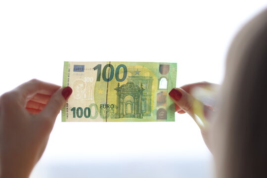 Woman checks authenticity of hundred euro bill