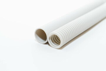 PVC rigid and flexible electrical conduit isolated on white background. Plastic curvilinear hoses....
