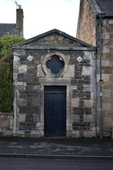 Fototapeta premium Street Facade of Old Stone Classical Building with Pediment-Door & Round Window