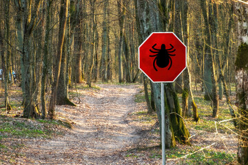 Warning sign beware of ticks in the spring forest, infested area. Transmitter Lyme disease and...