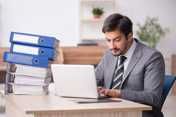 Young male employee unhappy with excessive work in the office