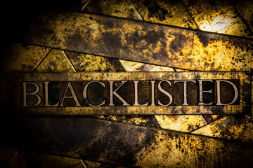 Blacklisted text formed with real authentic typeset letters on vintage textured silver grunge copper and gold background