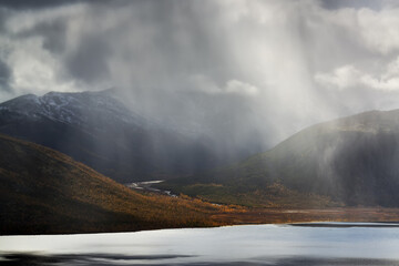 Rain over the lake in the valley of the mountains