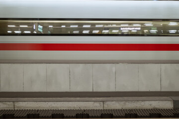 Horizontal interior view of platform railway train station and motion of white high speed train.