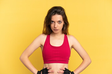 Young caucasian woman isolated on blue background posing with arms at hip