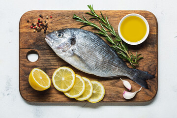 Fresh dorado on a cutting board with lemon and spices.