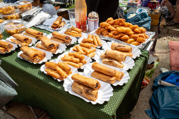 Set of Crispy spring rolls on white paper dish, sell on stall at Thai Park, open air market, in...