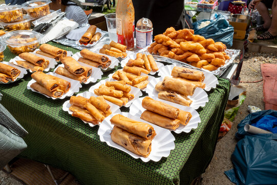 Set of Crispy spring rolls on white paper dish, sell on stall at Thai Park, open air market, in Berlin, Germany. Asian street food.