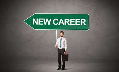Young business person in casual holding road sign