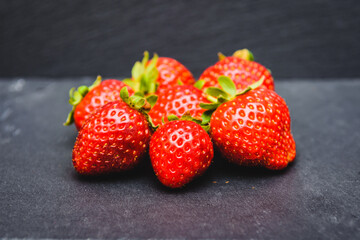 Strawberries on dark texture background