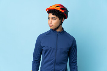 Venezuelan cyclist man isolated on blue background looking to the side - obrazy, fototapety, plakaty
