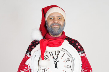 Santa Claus points to the clock before Christmas. Santa hat on the clock