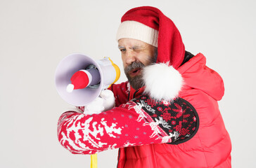 Santa Claus holds a loudspeaker in his hands, which is wearing a Santa hat.