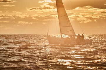 The lonely sailboat on the horizon in sea at sunset, the storm sky of different colors, big waves,...