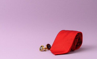 twisted silk red tie and cufflinks on a purple background