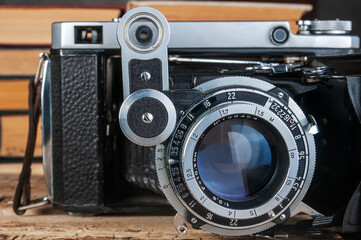 vintage folding film camera on wood background close-up