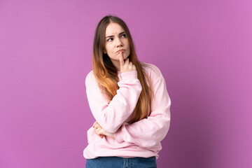 Young caucasian woman isolated on purple background having doubts while looking up