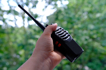 close-up female hand holds black gadget, portable radio station, receiving-transmitting device...