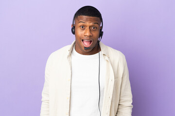 Telemarketer latin man working with a headset isolated on purple background with surprise facial expression