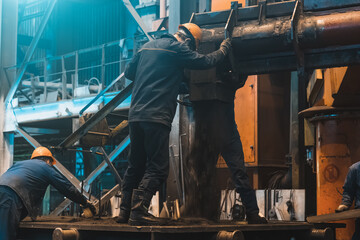 Workers in process of work with large mold iron cast on steel mill. Foundry workshop interior....