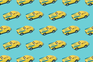 Old metal sport car toy yellow and blue color on blue background. Minimal design. Pattern.