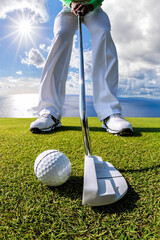 Man playing golf against azure sea in a coastal golf club - 448444024