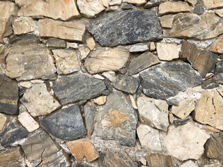 Old ancient wall with different stones as abstract background