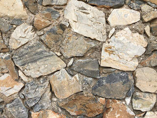 Old ancient wall with different stones as abstract background