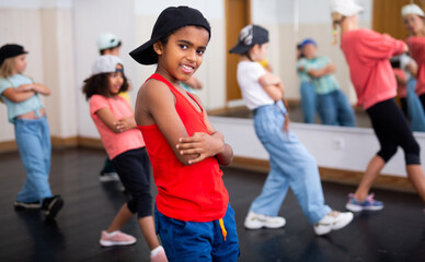 Portrait of confident tween african boy hip hop dancer posing during group dance class