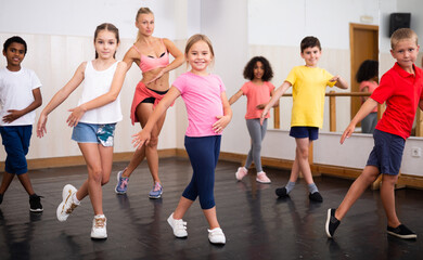 Fototapeta na wymiar Group of children training in class, learning dance movements
