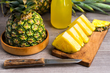pineapple and fresh pineapple slices with juice on the table