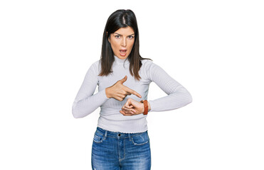 Beautiful brunette woman wearing casual clothes in hurry pointing to watch time, impatience, upset and angry for deadline delay