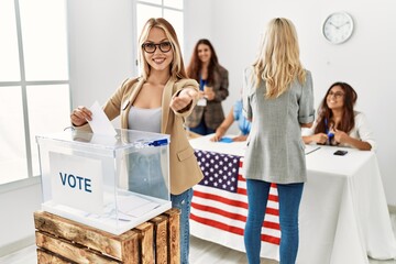 Group of young girls voting at democracy referendum smiling cheerful offering palm hand giving assistance and acceptance.