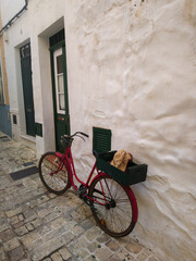 Red bicycle in front of a house in Ciutadella de Menorca street.