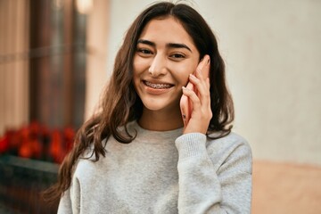 Young middle east girl smiling happy talking on the smartphone at the city.