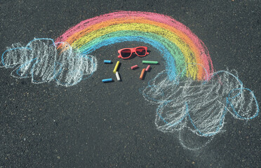 Children's drawing of a rainbow on the asphalt with crayons
