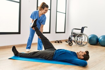 Young disabled man making mobility exercise at the clinic.