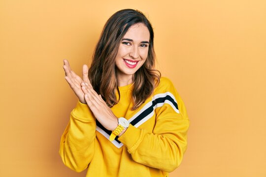 Young hispanic girl wearing casual clothes clapping and applauding happy and joyful, smiling proud hands together