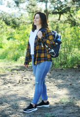 young woman with a bag spends time in the forest.
