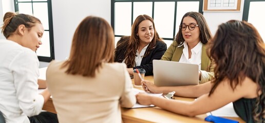 Group of young businesswomen smiling happy working at the office.