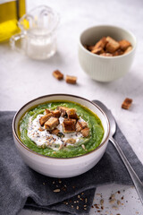 Rustic spinach and broccoli rich soup puree with cream and croutons