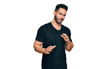 Hispanic man with beard wearing casual black t shirt disgusted expression, displeased and fearful...