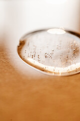 A drop of cosmetic gel on a beige background.