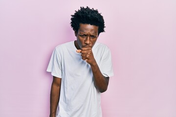 Young african american man wearing casual white t shirt feeling unwell and coughing as symptom for cold or bronchitis. health care concept.
