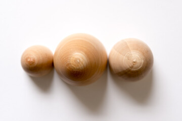 three wooden objects in shape of eggs on white