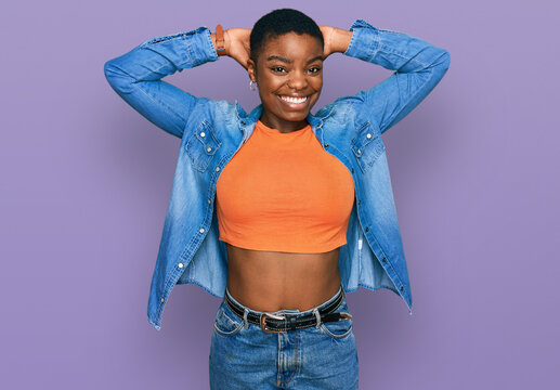 Young african american woman wearing casual clothes relaxing and stretching, arms and hands behind head and neck smiling happy