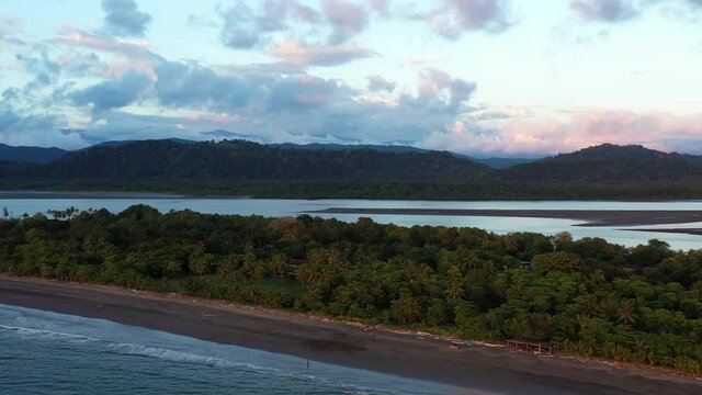 Tropical beach with palm trees mangrove mountains aerial sunset zancudo Costa Rica