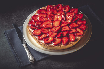 Homemade strawberry pie with syrup on a ceramic platter.